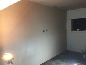 project for plasterer in didsbury - image shows hand holding trowel on wall